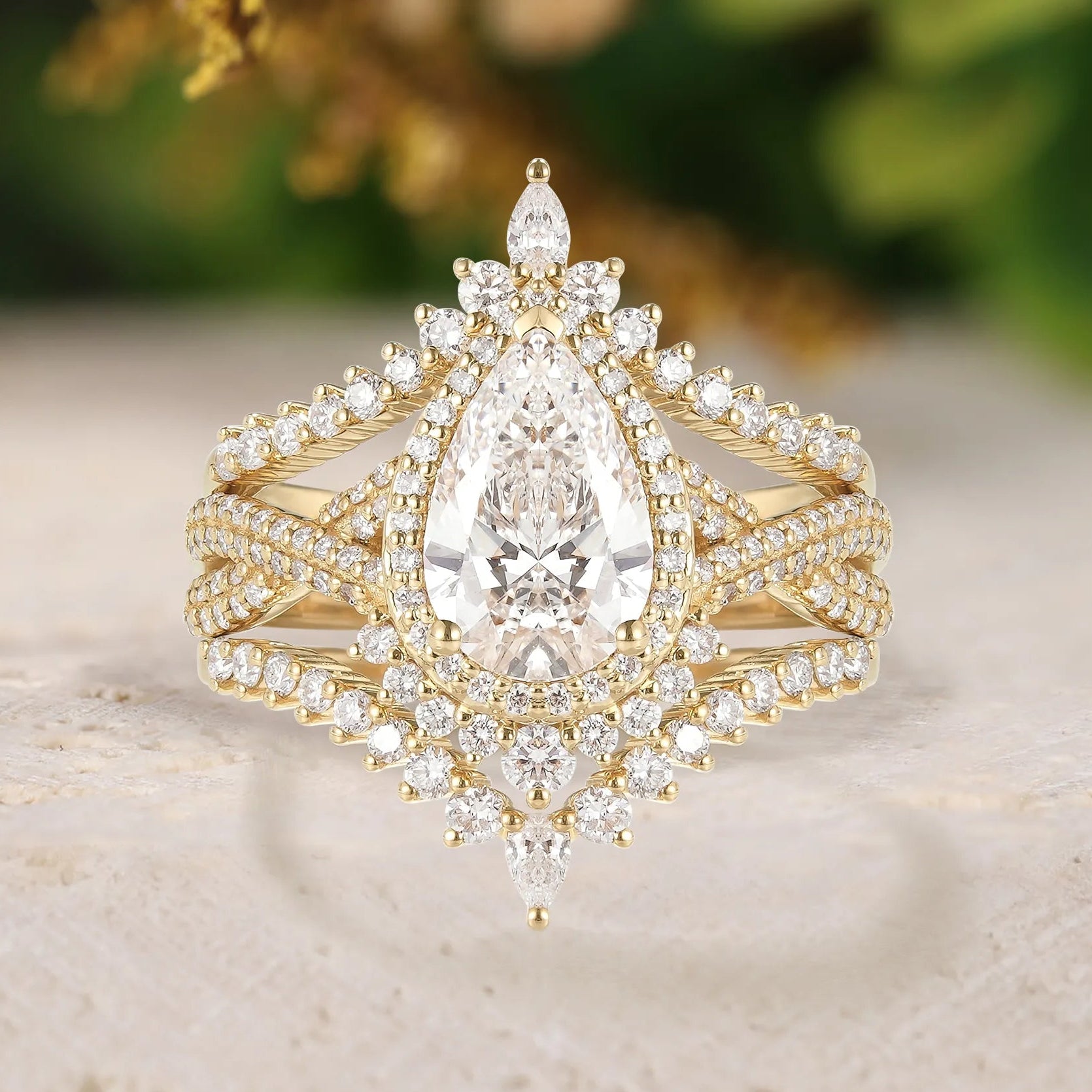 Gold and diamond ring on a textured surface with blurred greenery in the background