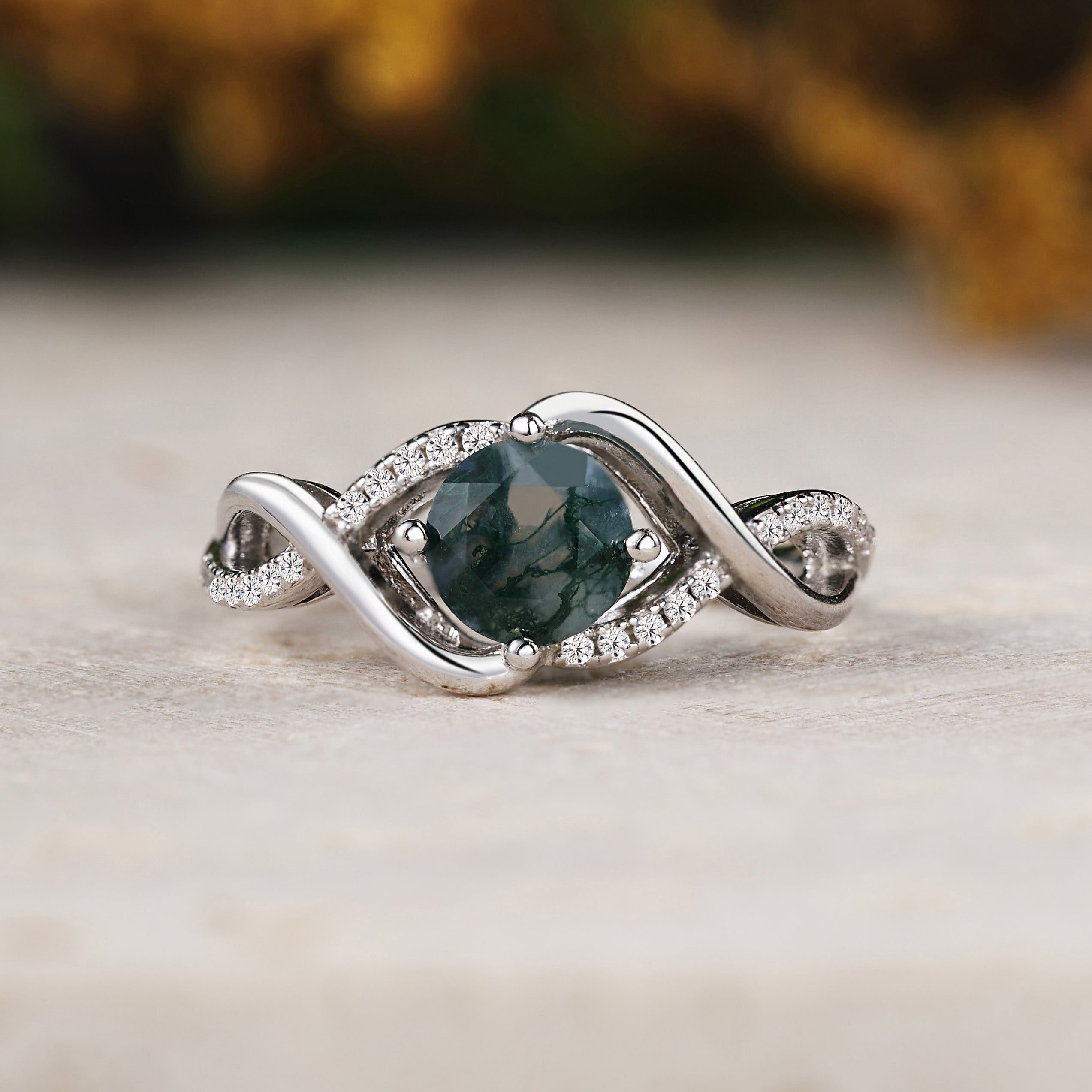 Silver ring with a green gemstone on a wooden surface
