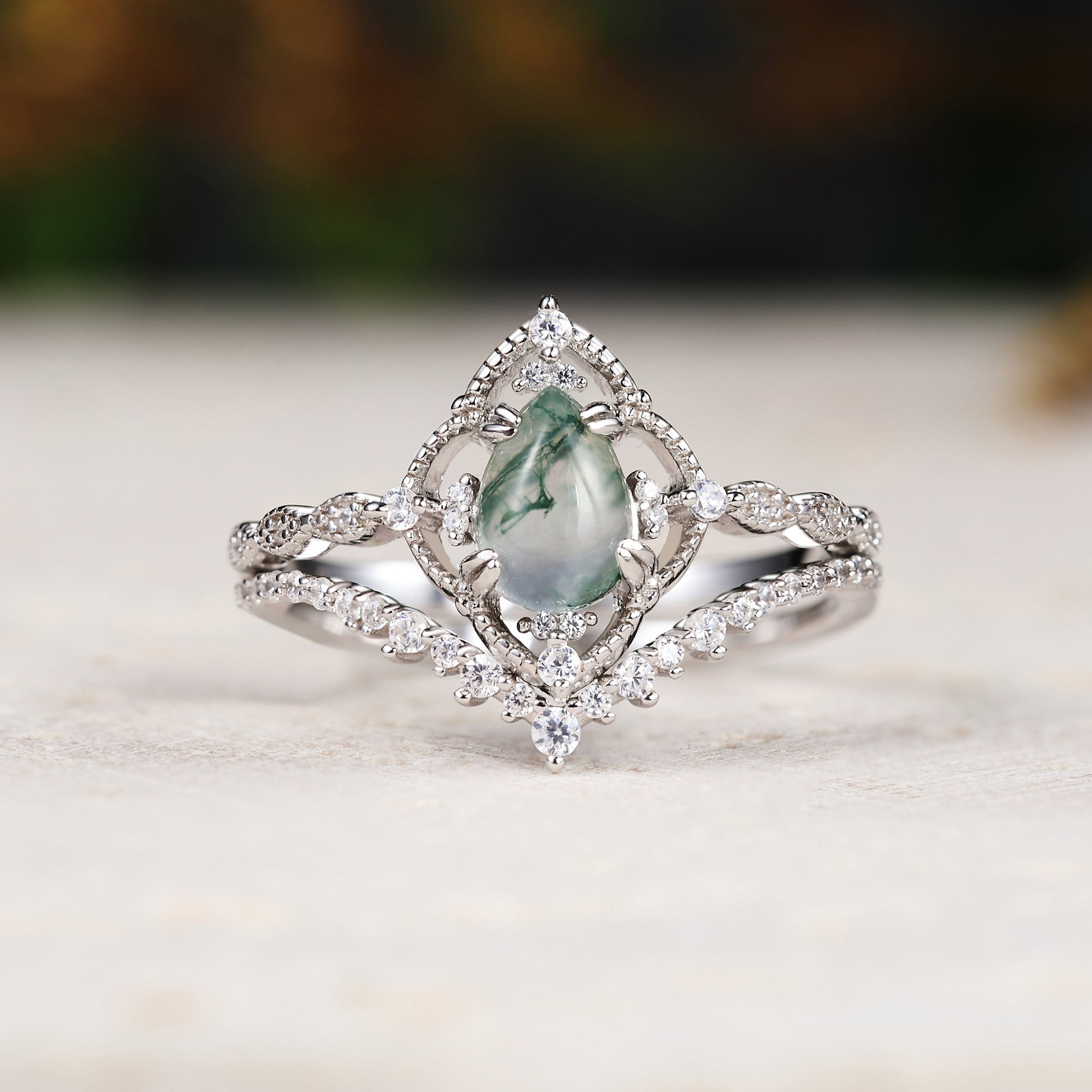 Silver ring with a green gemstone on a light surface