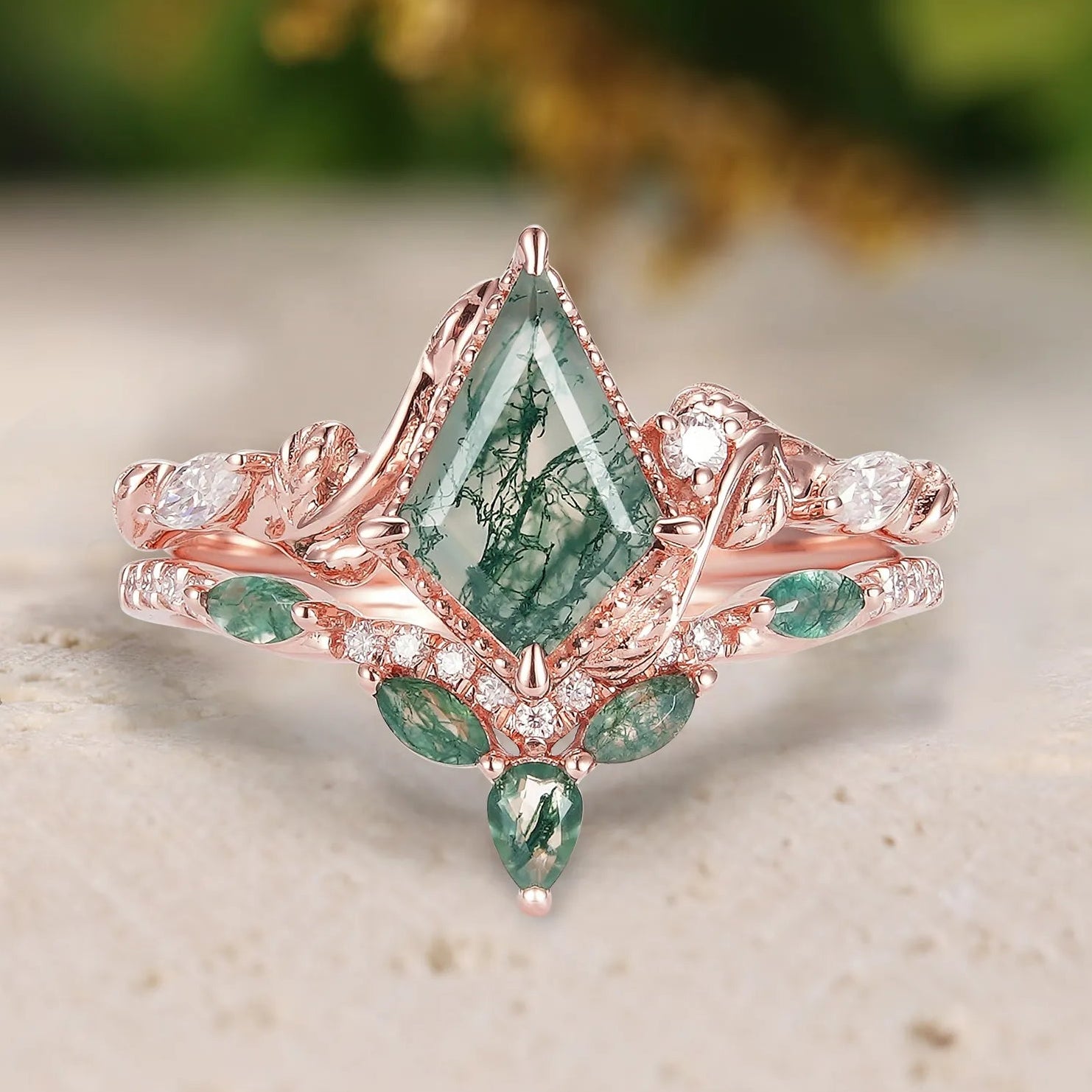 Rose gold ring with green gemstone on a light surface