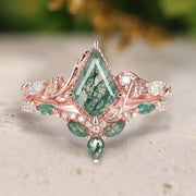 Rose gold ring with green gemstone on a light surface