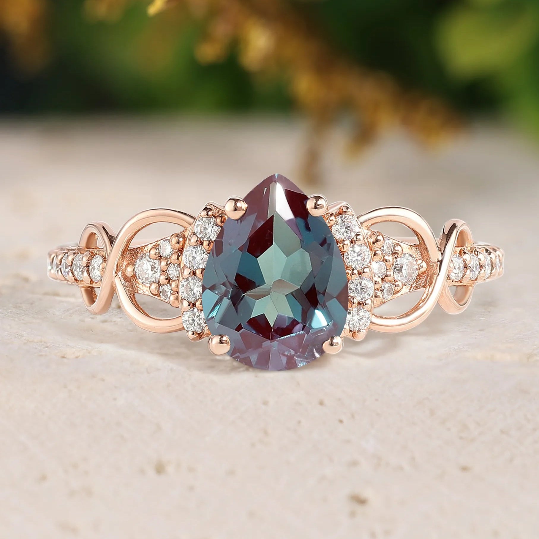 Rose gold ring with a large gemstone and smaller diamonds on a beige surface.