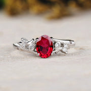 Silver ring with a red gemstone on a light background
