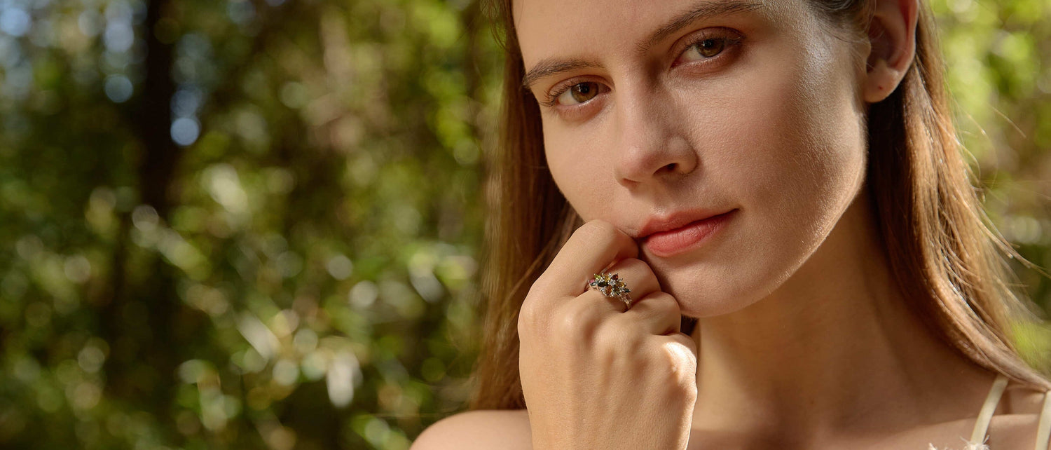 Woman with hand on chin in a forest setting