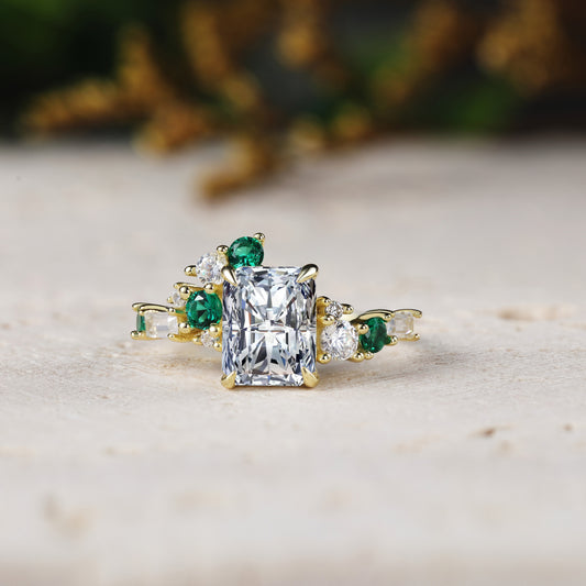 Gold ring with emerald and diamond accents on a light surface
