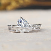 Silver ring with a pear-shaped diamond on a light surface