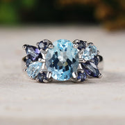 Ring with blue topaz and purple stones on a neutral background