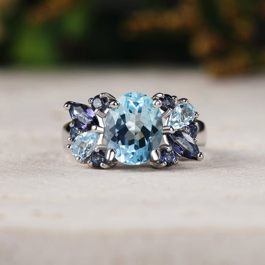 Ring with blue topaz and purple stones on a neutral background