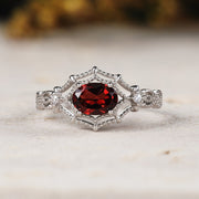 White gold ring with a red gemstone on a light background