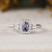 Silver ring with a purple gemstone on a light wooden surface