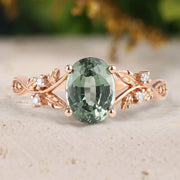 Rose gold ring with a green gemstone on a neutral background