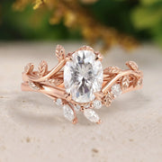 Rose gold ring with a large diamond and leaf designs on a light background