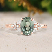 Green gemstone ring with rose gold setting on a neutral background
